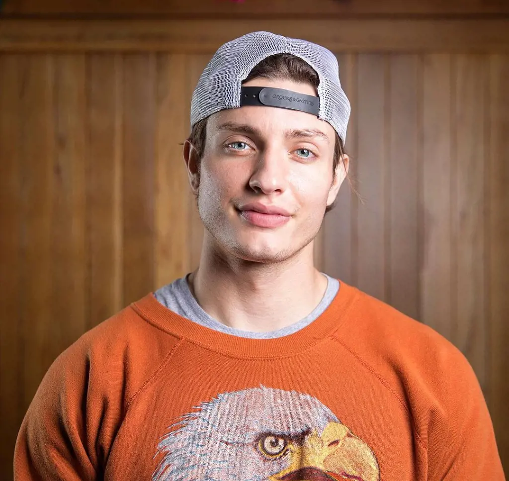 Matt wearing an orange vintage bird sweater and cap in this photograph captured by Foto MatTeo in March 2021